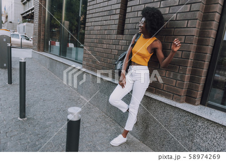 Gorgeous lady wearing stylish clothes leaning on the wall 58974269