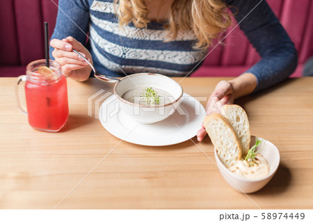 Crop of woman holding spoon and white bowl of Crop of woman holding spoon and white bowl of 58974449