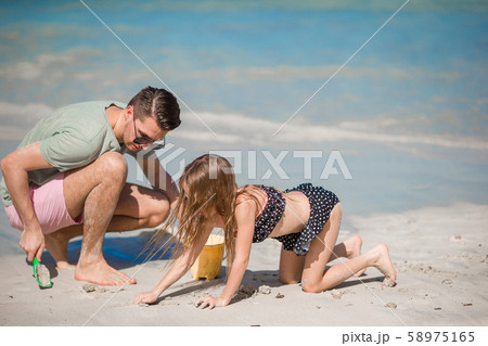 Little girl and happy dad having fun during beach vacation 58975165