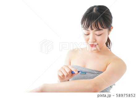 肌の脱毛をする若い女性 肌の脱毛をする若い女性 58975852