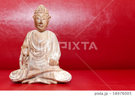 Wooden statue of Buddha, symbol of Buddhism on red Wooden statue of Buddha, symbol of Buddhism on red 58976005