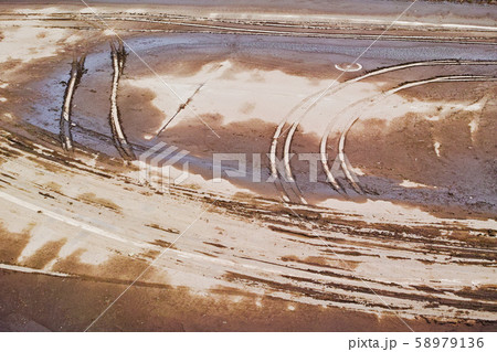 水が引いた後の今田遊水地の半乾きの舗装路面に残る轍 水が引いた後の今田遊水地の半乾きの舗装路面に残る轍 58979136