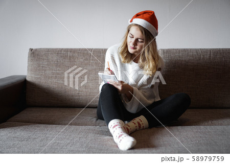 Portrait of pretty girl at Christmas writes plans for the new year Portrait of pretty girl at Christmas writes plans for the new year 58979759