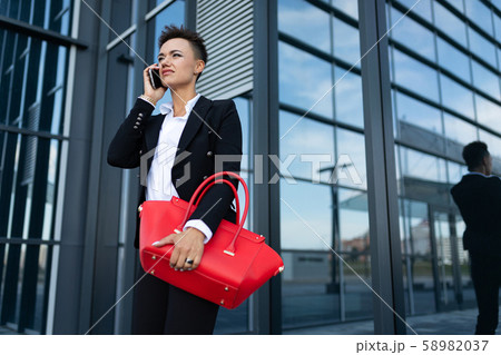 photo of a young ambitious businesswoman on the background of a modern office building photo of a young ambitious businesswoman on the background of a modern office building 58982037
