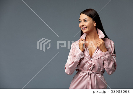Girl in pink overalls poses for the camera on a gray background. Isolate, copy space. 58983068