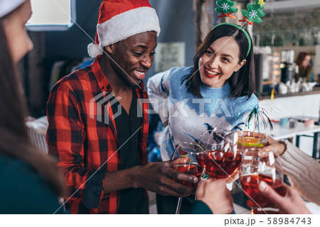 Happy young people with glasses celebrating Christmas or New Year eve. 58984743