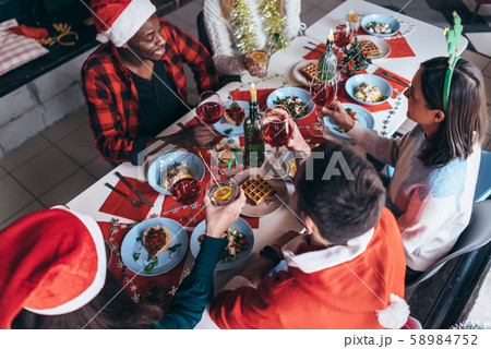 People sit at a festive table and celebrate new year's eve or Christmas. 58984752