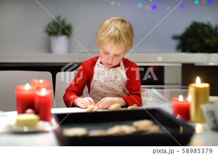 Merry little boy bake cookies during holidays 58985379