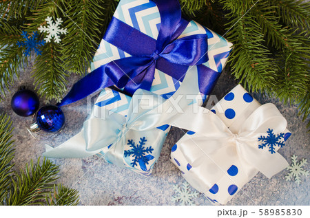 Christmas background. Gift boxes and fir branches with decoration in blue color. Christmas background. Gift boxes and fir branches with decoration in blue color. 58985830