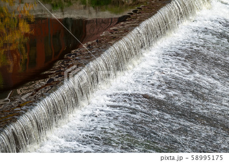 A small flat cascade in a calm river A small flat cascade in a calm river 58995175