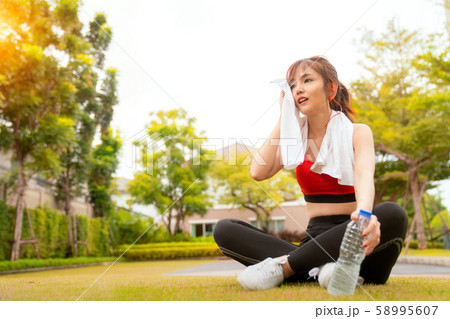 Asian girl relax and drinking after running in her 58995607