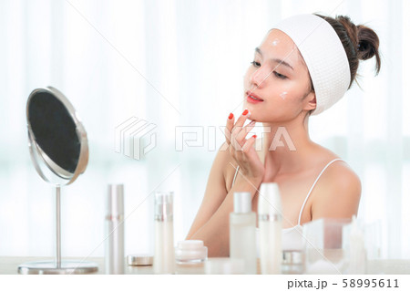Asian girl apply moisturizer cream Asian girl apply moisturizer cream 58995611