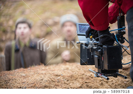 A man with camera in hand is filming the actors 58997018