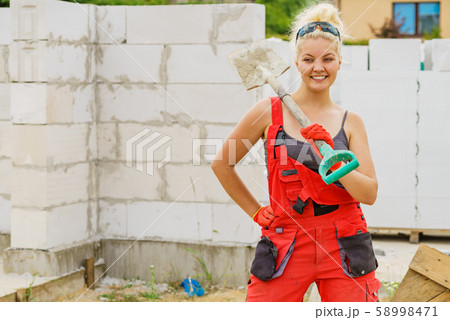 Woman using shovel on constriction site 58998471