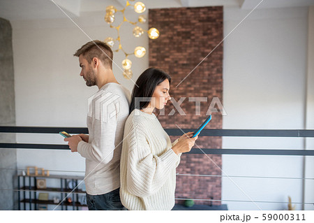 Couple addicted to social media using gadgets instead of talking 59000311