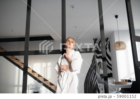 Woman after having bath standing in living room 59001152