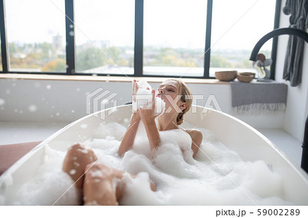 Blonde woman chilling in foamy bath having much fun 59002289