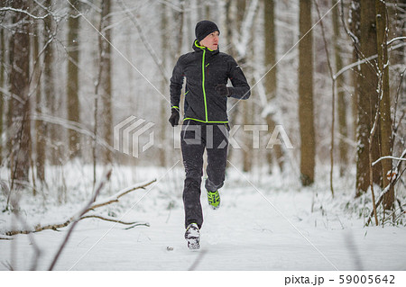 Photo of man in sportswear, black hat jogging in winter Photo of man in sportswear, black hat jogging in winter 59005642
