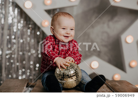 Happy newborn boy smiling sitting on background decor Happy newborn boy smiling sitting on background decor 59006949