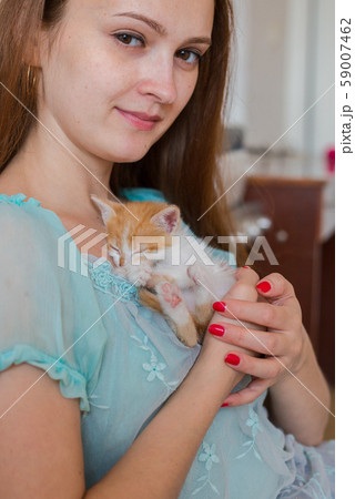 Close up of cute kitty in woman's hands. 59007462