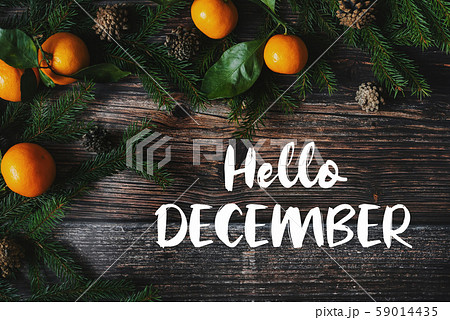 wooden background and tangerines with cones and text Hello December 59014435