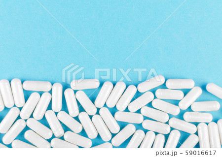 white medicine capsules on blue background with copy space white medicine capsules on blue background with copy space 59016617