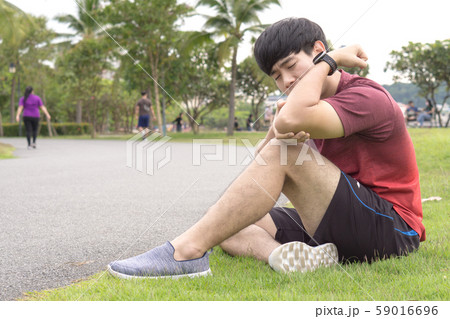 A male athlete suffering from arm and elbow pain and injury at the park. Sport and healthcare concept. 59016696