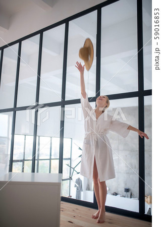 Cheerful woman throwing hat in the air while having fun Cheerful woman throwing hat in the air while having fun 59016853