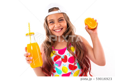 baby in a swimsuit with an orange and freshly squeezed juice in her hands smiling baby in a swimsuit with an orange and freshly squeezed juice in her hands smiling 59016923