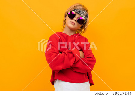 self-confident schoolboy on a yellow background in a red hoodie self-confident schoolboy on a yellow background in a red hoodie 59017144