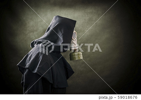 Man in a gas mask and hooded cloak. Environment pollution. Man in a gas mask and hooded cloak. Environment pollution. 59018676