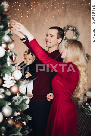 Beautiful family decorating Christmas tree Beautiful family decorating Christmas tree 59019439
