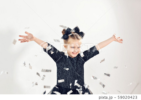 Party, holidays, new year and celebration concept - Female child throwing confetti. 59020423