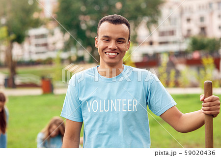 Volunteering. Young people volunteers outdoors planting trees guy standing with shovel close-up Volunteering. Young people volunteers outdoors planting trees guy standing with shovel close-up 59020436