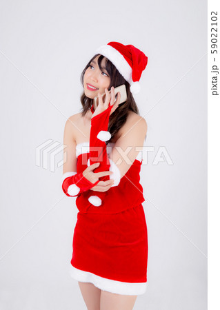 Beautiful portrait young asian woman in Santa talking smartphone in xmas day isolated 59022102
