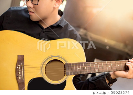 Asian man guitarist playing music with guitar Asian man guitarist playing music with guitar 59022574