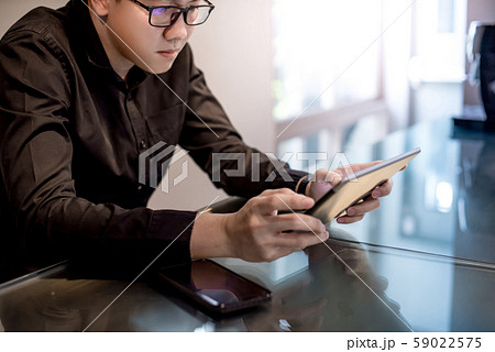 Asian businessman using digital tablet in office Asian businessman using digital tablet in office 59022575