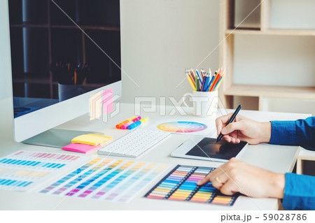 Graphic designer drawing on graphics tablet at 59028786