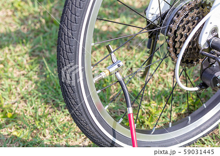 パンクした白い折りたたみ自転車_電動空気入れ・パンク修理_無人・人物無し 59031445