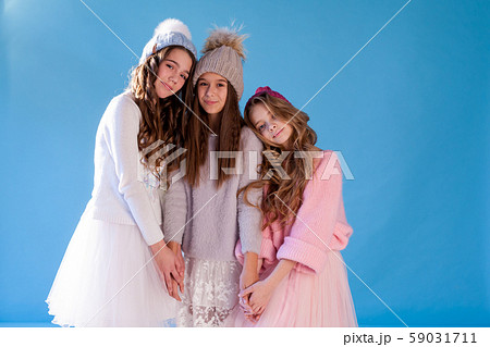 three beautiful girls in winter hats and warm clothes three beautiful girls in winter hats and warm clothes 59031711
