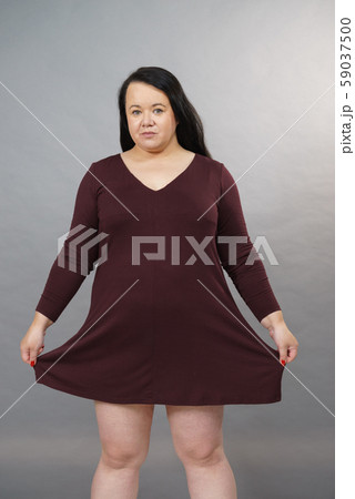 Woman showing size of brown top tunic 59037500