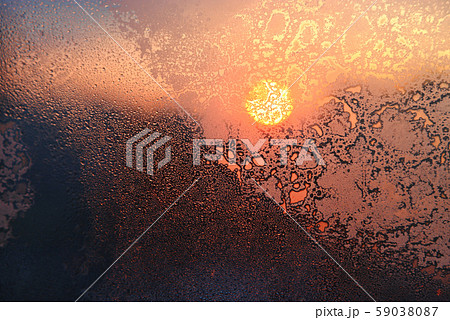 Ice patterns, water drops and sunlight on a window 59038087