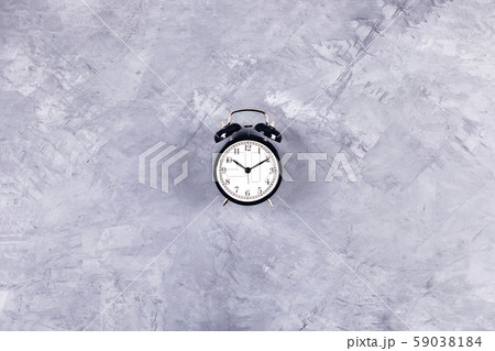 Black clock on grey concrete background. 59038184