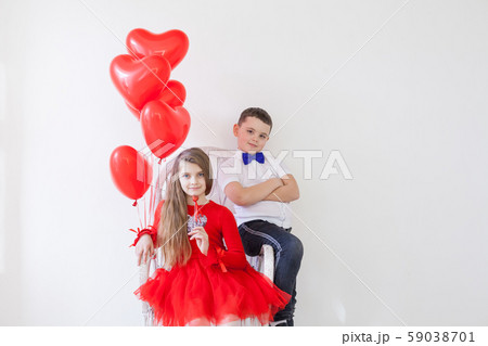 Kids with red balloons for birthday in the interior of the white room Kids with red balloons for birthday in the interior of the white room 59038701