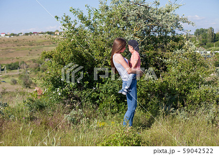 Mom with young son playing in the garden on the grass Mom with young son playing in the garden on the grass 59042522