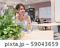 休憩中に笑顔でワイヤレスイヤホンで音楽を聴く若い女性 59043659