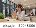 休憩中に笑顔でワイヤレスイヤホンで音楽を聴く若い女性 59043660