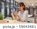 休憩中に笑顔でワイヤレスイヤホンで音楽を聴く若い女性 59043661
