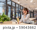 休憩中に笑顔でワイヤレスイヤホンで音楽を聴く若い女性 59043662