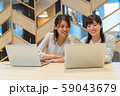 パソコンに向かって笑顔で作業をする二人の若い女性 59043679